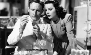 Hedy Lamarr, actrice et inventrice, observe un homme en blouse blanche manipulant des éprouvettes dans un laboratoire.