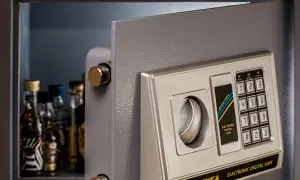 Coffre fort numérique gratuit ouvert, révélant des petites bouteilles. Clavier électronique pour un accès sécurisé.