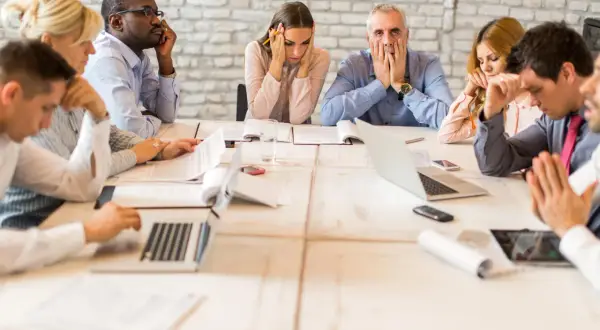 Des employés semblent dépassés lors d'une réunion. Comment organiser une réunion pour éviter cette situation ?