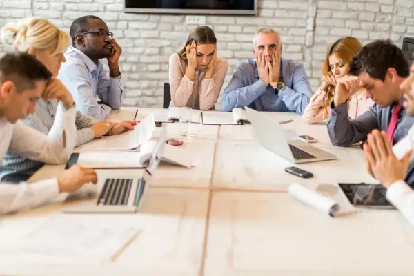 Des employés semblent dépassés lors d'une réunion. Comment organiser une réunion pour éviter cette situation ?